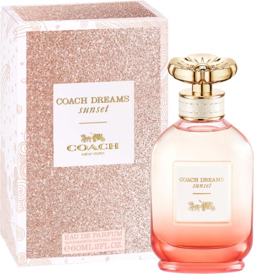 A perfume bottle and box labeled Coach Dreams Sunset, pink and gold design, elegant and luxurious look.