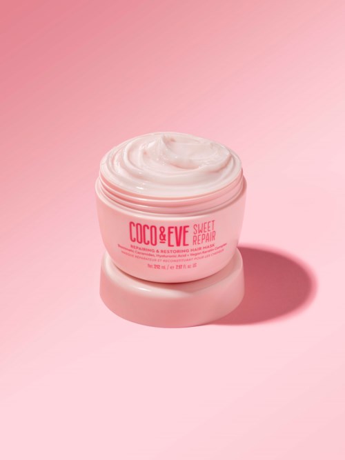 A pink jar of Coco & Eve Sweet Repair hair mask on a matching pink surface and background.