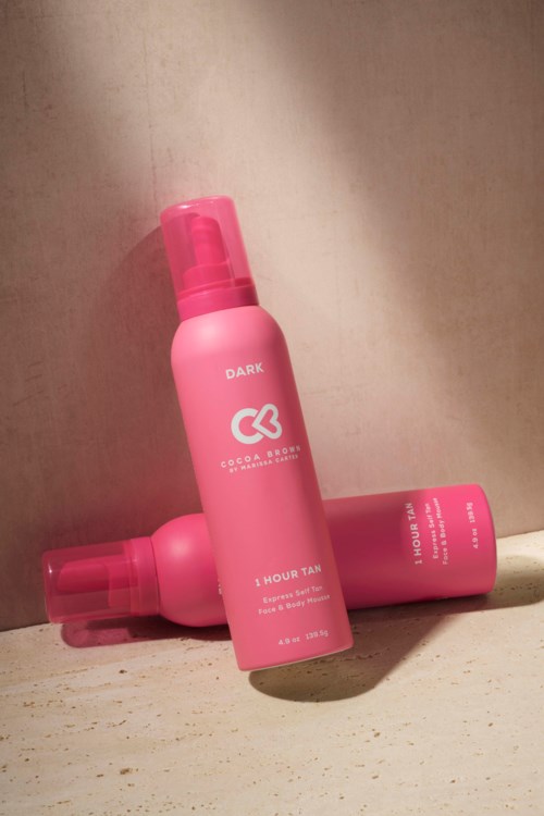 Zwei pinke Sprühflaschen, eine aufrecht und eine liegend, auf heller Oberfläche.