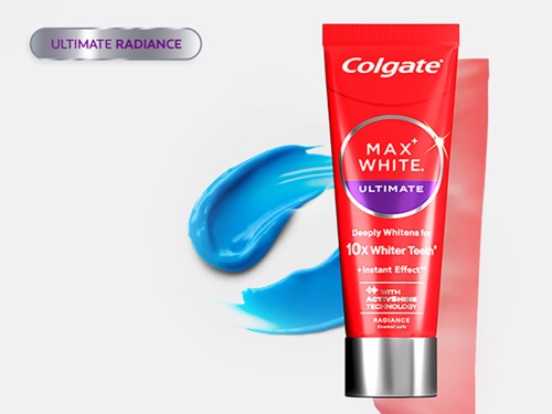 En tub med Colgate Max White tandkräm med blå tandkrämssväng och en etikett som lyfter fram blekningsfördelar.