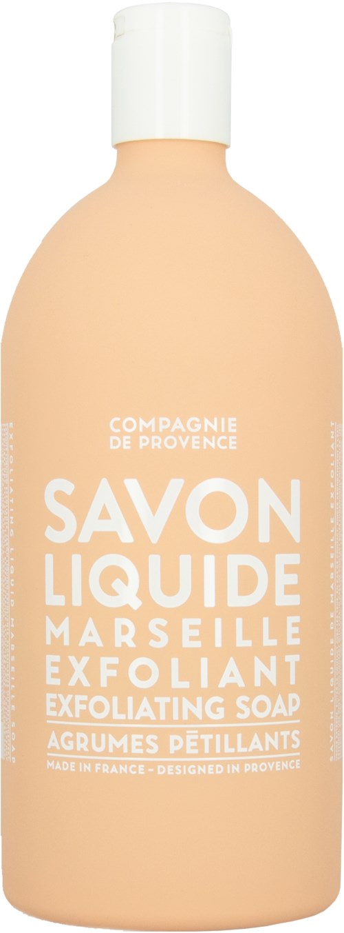 A peach-colored bottle with white cap, labeled as exfoliating soap from Marseille by Compagnie de Provence.
