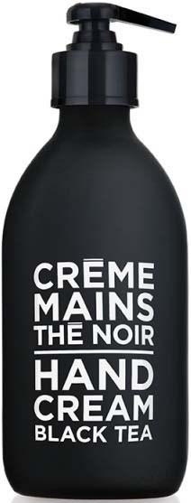 A black bottle with a pump labeled 'Hand Cream Black Tea' and 'Crème Mains The Noir.'