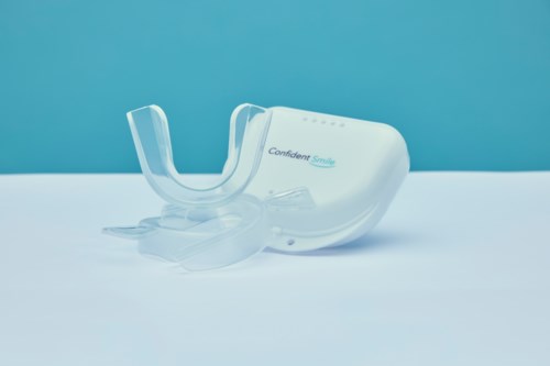 A small white dental device with a transparent mouthpiece and blue text: Confident Smile.