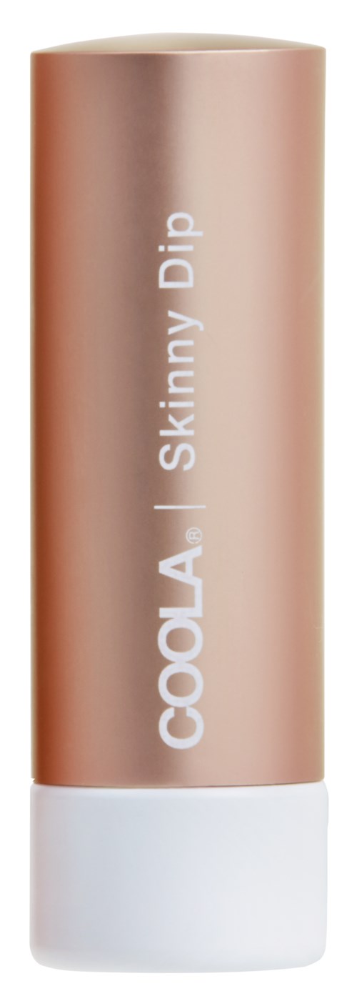 En beige tube med ordene "COOLA Skinny Dip" på, hvit cap nederst.