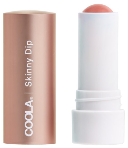 En beige lepperbalsamrør med etiketten 'COOLA Skinny Dip' og en hvit hetten som viser en rosa balsamstang.