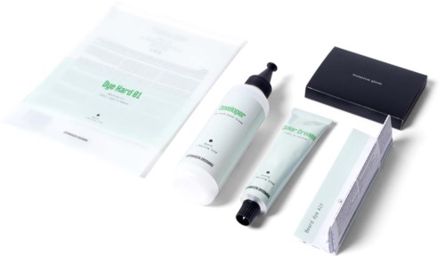 Skincare products including a bottle, a tube, a box, and instructions or packaging. All items are neatly arranged.
