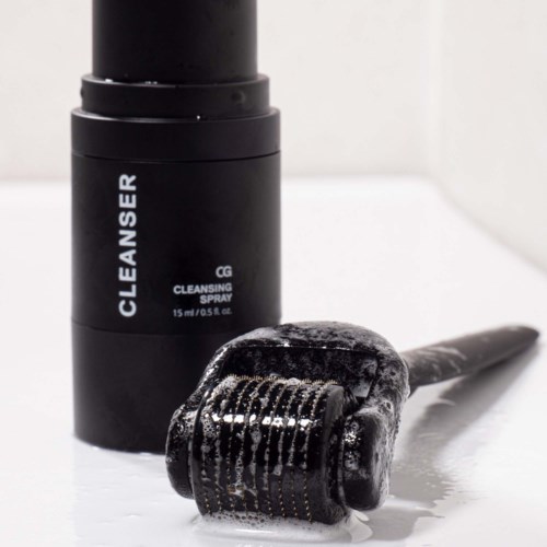 A black bottle labeled 'Cleanser Cleaning Spray' beside a hair roller with foam on it.