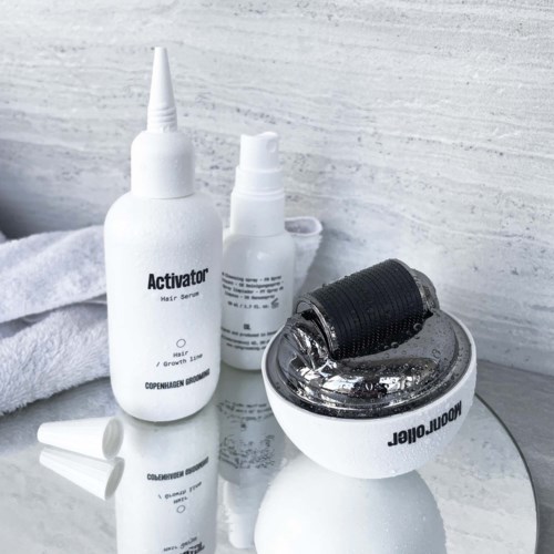 A skincare set with bottles and a roller, including a serum, spray, and a device for skin treatment.