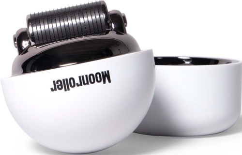 A white bowl with the word "Mooreoller" upside down, and a black roller attached on top, appears to be a kitchen tool.