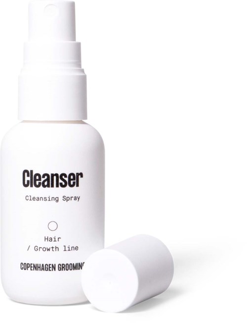 A white spray bottle labeled 'Cleanser' for hair or grooming, with a white cap beside it.