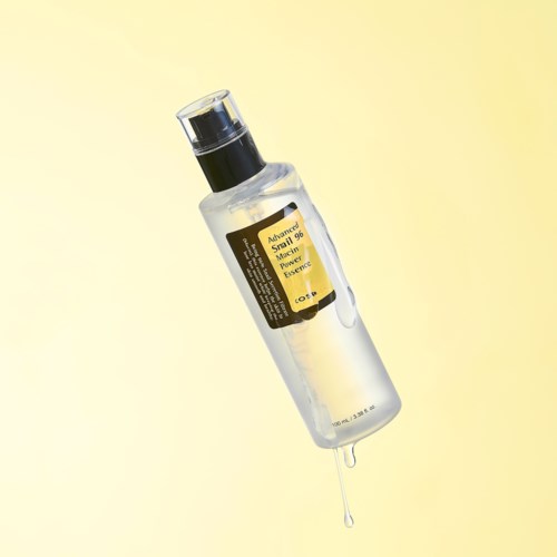 A clear bottle with a black pump, labeled 'Advanced Skin 90 Power Lift Essence,' with some liquid dripping from it.