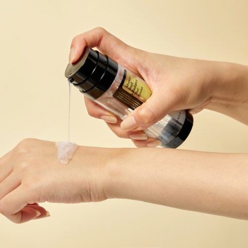 Iemand brengt huidverzorgingscrème uit een fles aan op de arm.