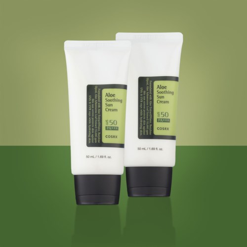 Twee tubes Aloe Soothing Sun Cream met SPF 50 staan op een groene achtergrond.