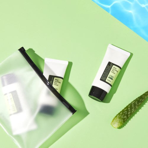Two aloe skincare products, one in a tube and one in a container, placed on a green background with a section of aloe vera.