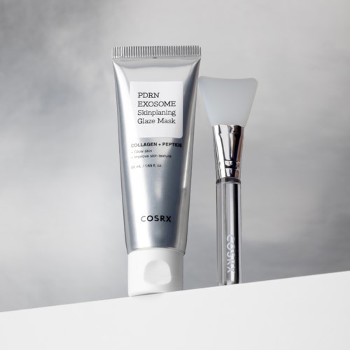Een zilverkleurige tube met het label 'PDRN EXOSOME Skinplaning Glaze Mask' en een witte kwast staan op een witte ondergrond.