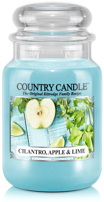 A blue scented candle in a glass jar with a label showing apple, lime, cilantro, and green leaves.