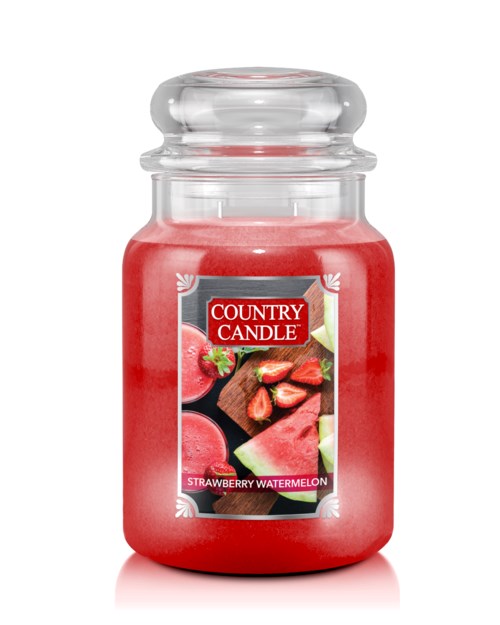 A red candle in a glass jar labeled "Country Candle" with a strawberry watermelon flavor.