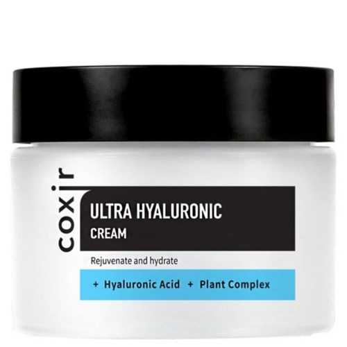 Ein weißer Behälter mit schwarzem Deckel, beschriftet "Coxir Ultra Hyaluronic Cream" mit Hyaluronsäure und Pflanzenkomplex, für Hautfeuchtigkeit.