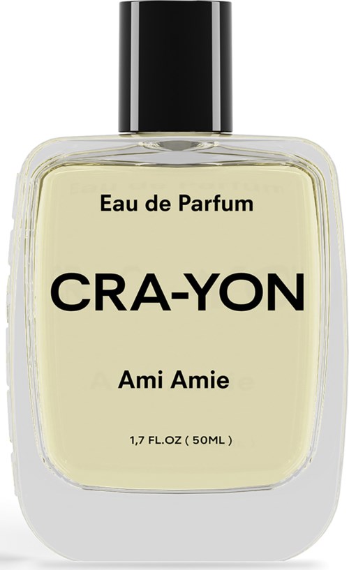 Parfumfles met 'Cra-Yon Ami Amie' label, zwart deksel, doorzichtig glas, lichtgele vloeistof.