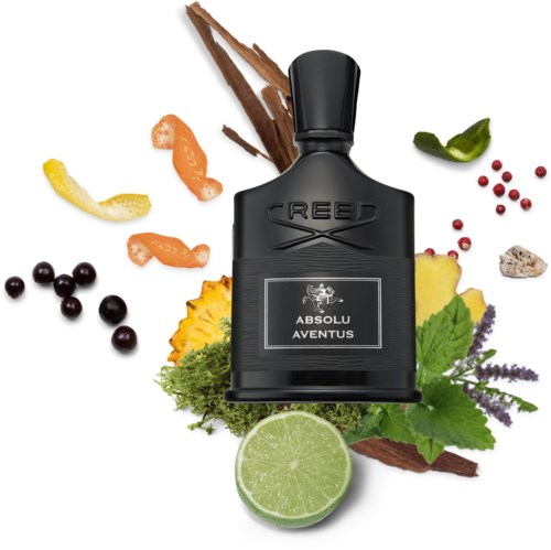 A black bottle of Creed Absolu Aventus perfume surrounded by herbs, fruits, and spices.
