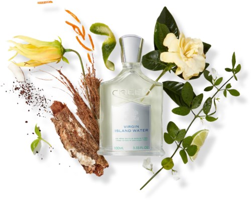 En flaske Virgin Island Water-parfyme omgitt av tropiske blomster, blader og en lime.