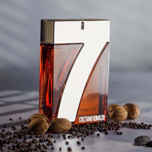 Ein Parfümflasche in Form der Zahl 7, mit Kaffeebohnen und Nüssen drumherum, und Cristiano Ronaldos Namen.