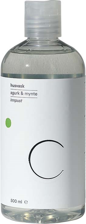 En tydlig flaska med vit etikett, liten grön prick och stort svart bokstav "C."