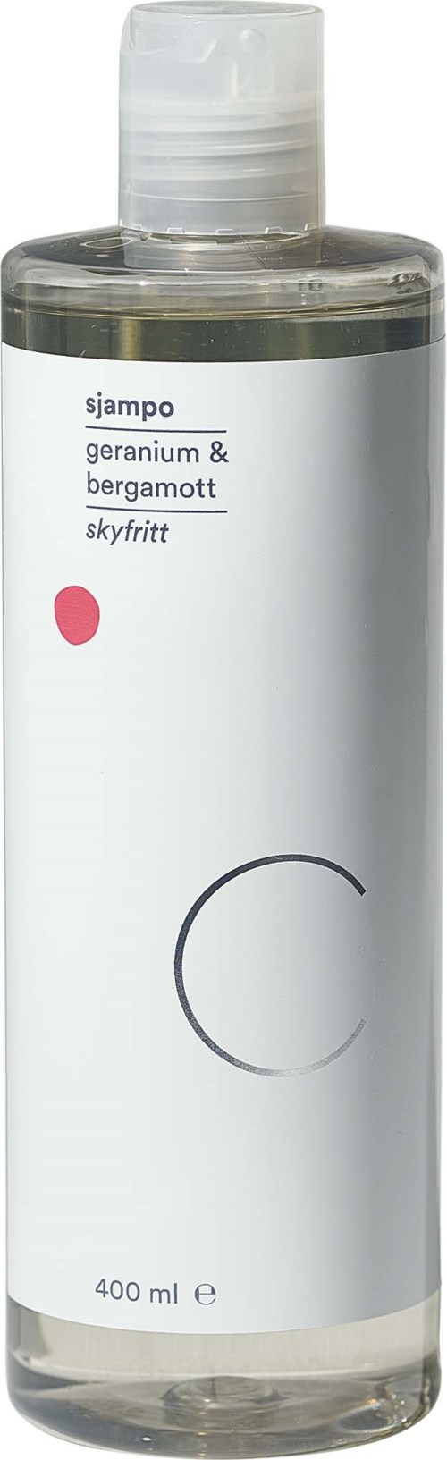 Clear bottle with a white label, black text listing ingredients, small pink dot, and a gray circle design.