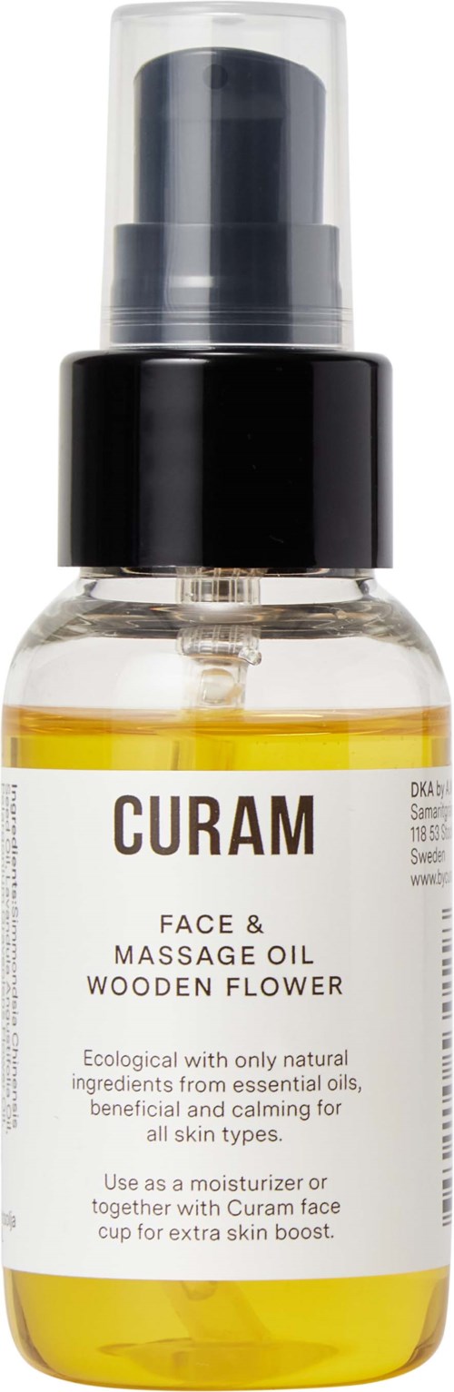 Eine kleine klare Flasche mit schwarzem Pumphahn, beschriftet 'Curam Face & Massage Oil Wooden Flower'.