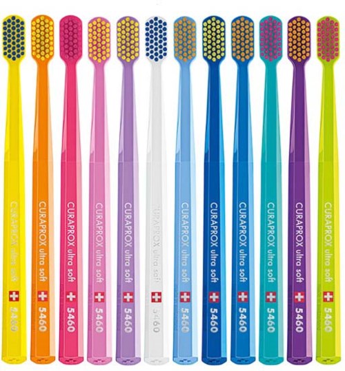 Colorful toothbrushes lined up in a row, each with a different bright color and a small Swiss flag on the handle.