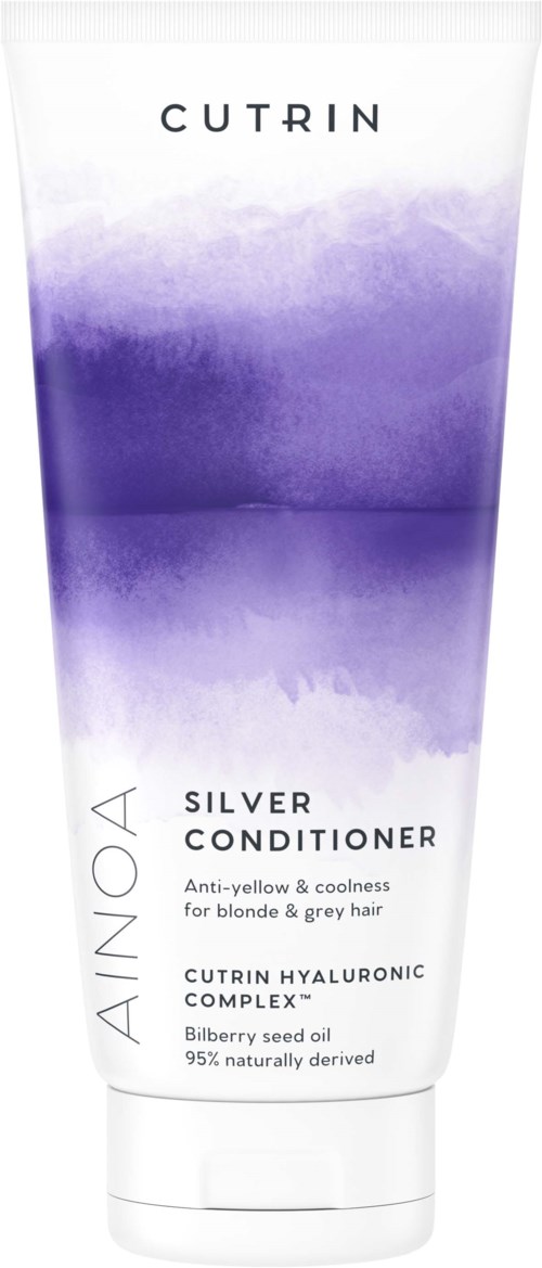 En tube med gullfarget balsam med lilla design, inneholder ingredienser som blåbæregfrøolje og hyaluronsyre.