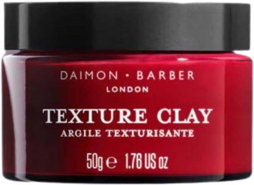 Roter Behälter mit schwarzem Deckel, beschriftet 'Daimon Barber Texture Clay,' 50g, für Haarstyling.