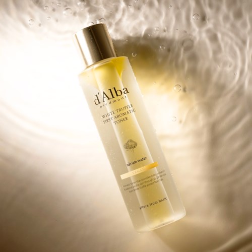 Eine Flasche d'Alba white trunk first aromatic toner mit Serumwasser schwimmt auf einer hellen, reflektierenden Oberfläche.