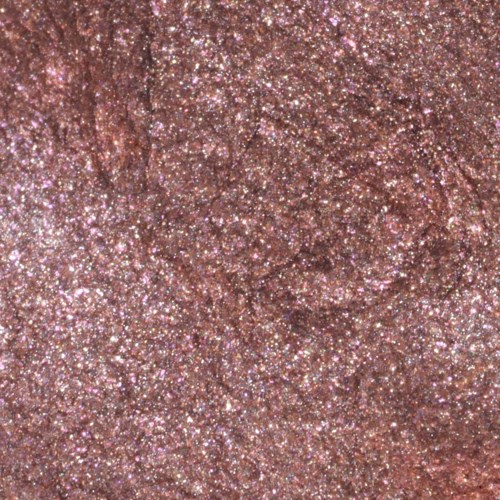En närbild av en glittrig, texturerad yta med många små gnistor, mest rosa och silverfärger.