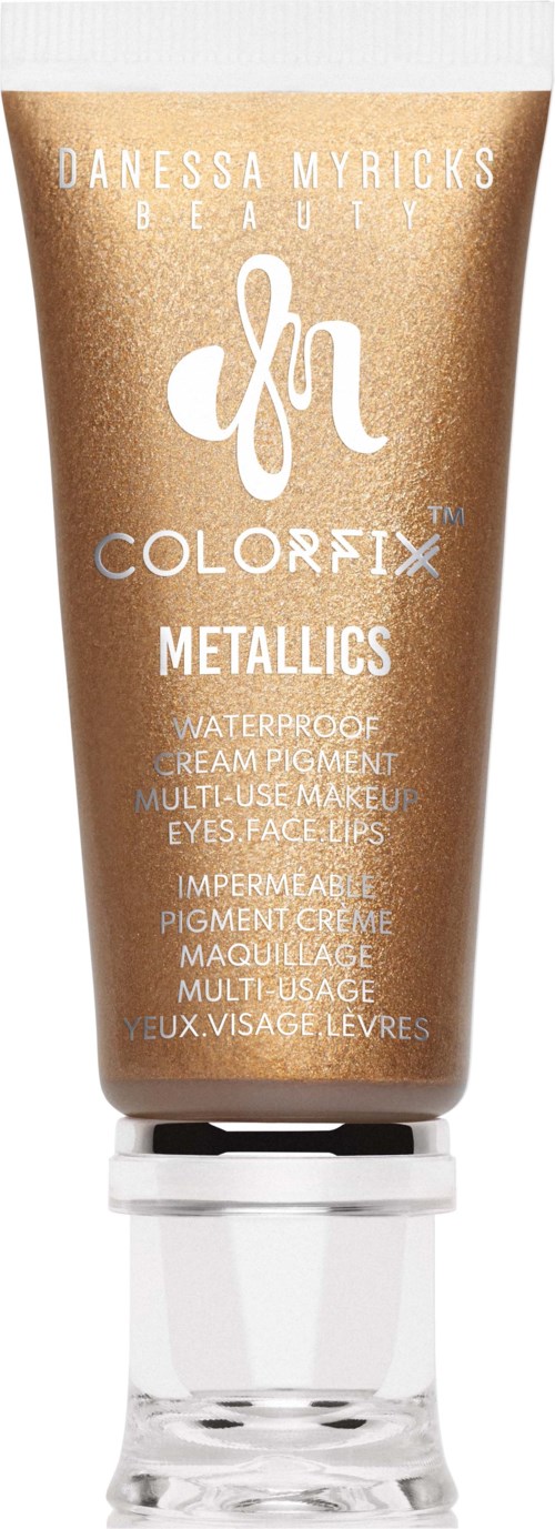 Een bronzen tube make-upcrème, gemarkeerd 'Danessa Myricks Beauty', 'Colorfix' en 'Metallics' voor ogen, gezicht en lippen.
