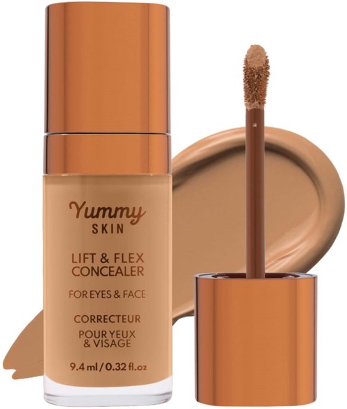A beige concealer bottle with a shiny copper cap and applicator, showing a swatch of concealer on beige background.