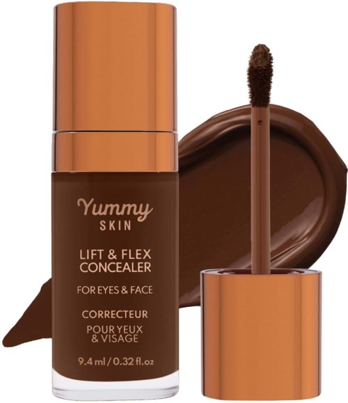 A brown concealer bottle with a gold cap, a swatch of concealer, and an applicator stick.