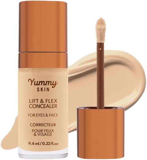 A concealer bottle with a sponge applicator and beige cream spread behind it.