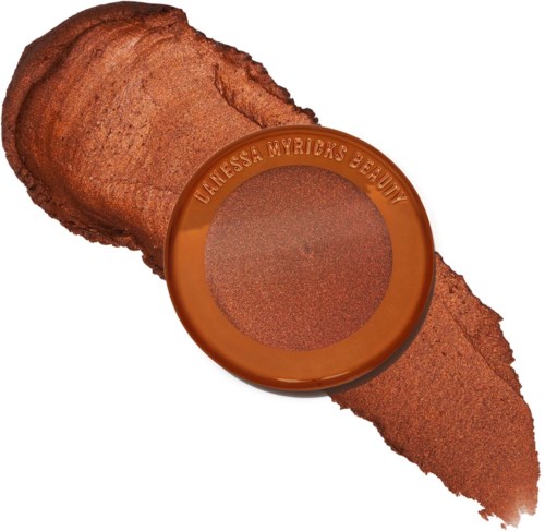 Een rond make-upproduct met de merknaam Vanessa Myrick's Beauty, omringd door bronzekleurig poeder.