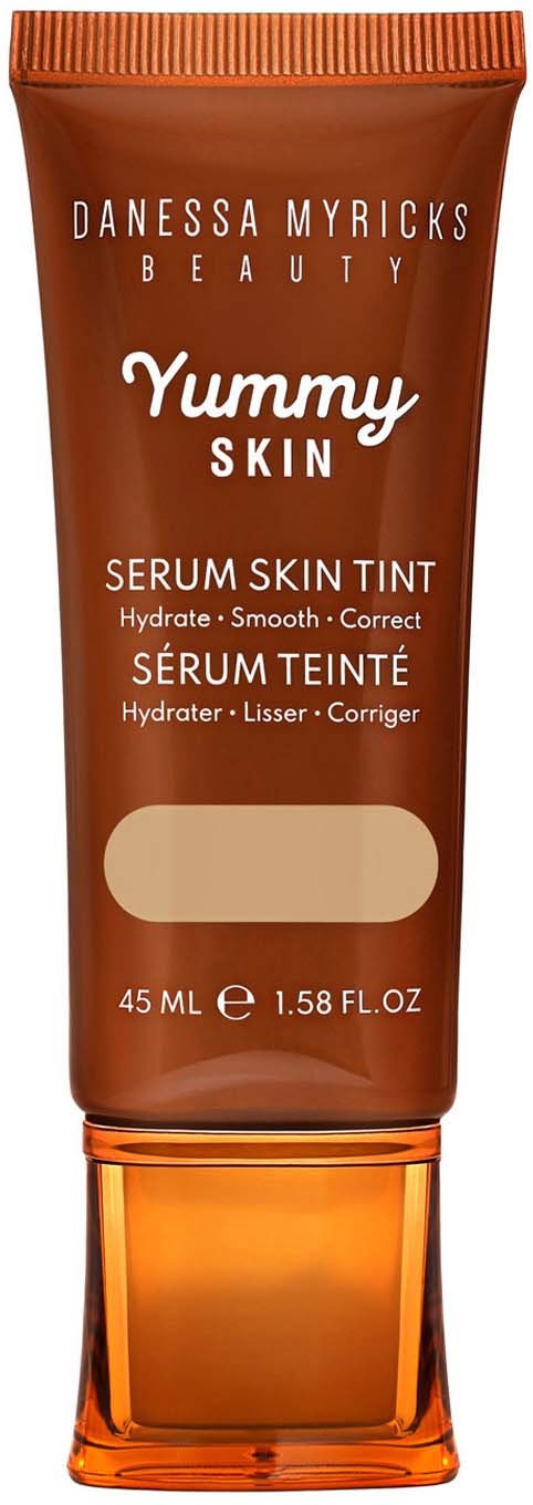 A tube of Danessa Myricks Beauty serum skin tint, brown color, with a flip cap, describes hydration and smooth skin.