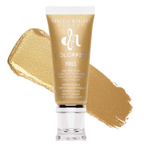 Goudkleurige tube van Danessa Myricks FACE FOILS vloeibaar glitterpigment voor ogen, gezicht en lippen. Goudkleurige test eronder.