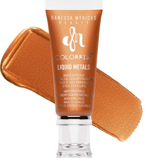 A copper-colored tube of liquid metal makeup with a silver cap, with a metallic swatch behind it.