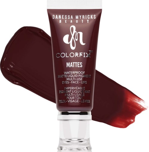 A maroon tube of Danessa Myricks Beauty Colorfix Mattes waterproof liquid pigment next to a smear of deep red lipstick.