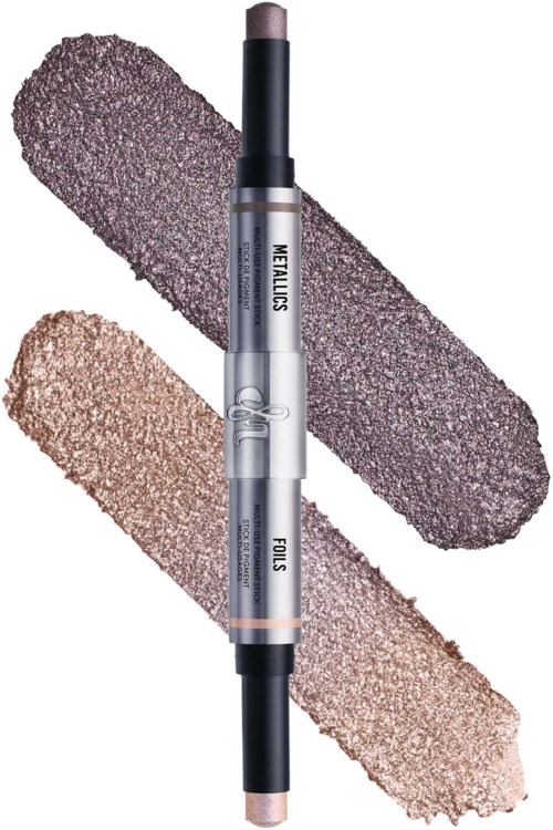 Twee metallic make-up potloden, een donkerpaars en een lichtgoud, kruisen elkaar met swatches erachter.