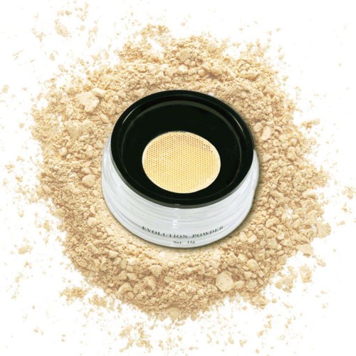 En kompaktpuder med en beige svamp inuti, på en bädd av lös beige puder.