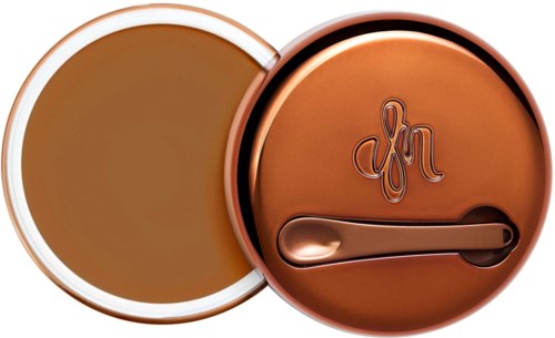 Round container with a lid, featuring a signature and a small spoon inside.