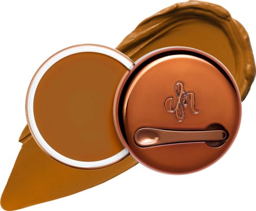 A small container with a lid, and brown cream or sauce underneath with scribbled writing on the lid.