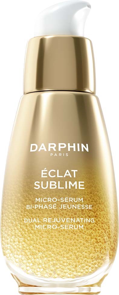 Eine goldene Flasche mit weißem Pumpaufsatz, beschriftet Darphin Éclat Sublime Micro-Serum, mit punktiertem Muster am unteren Ende.
