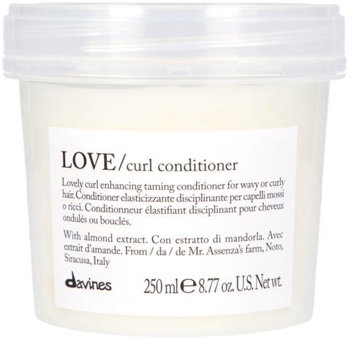 En vit burk innehåller Love curl balsam med mandel extrakt för vågigt eller lockigt hår.