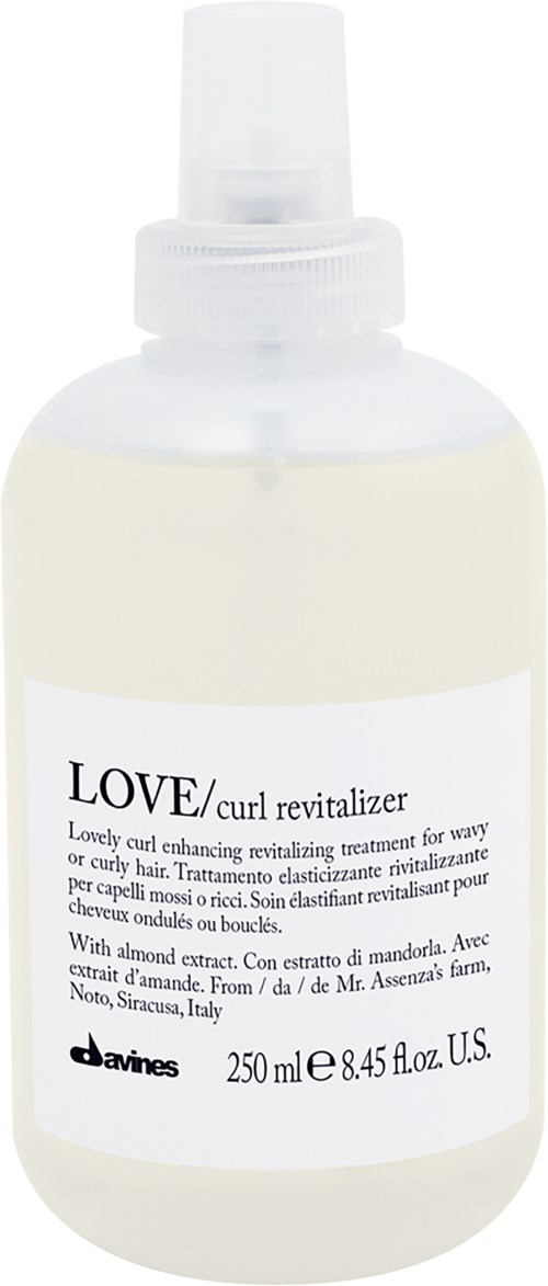 A white spray bottle labeled 'LOVE/curl revitalize' for hair, containing 250 ml of hair treatment with almond and mandra extract.